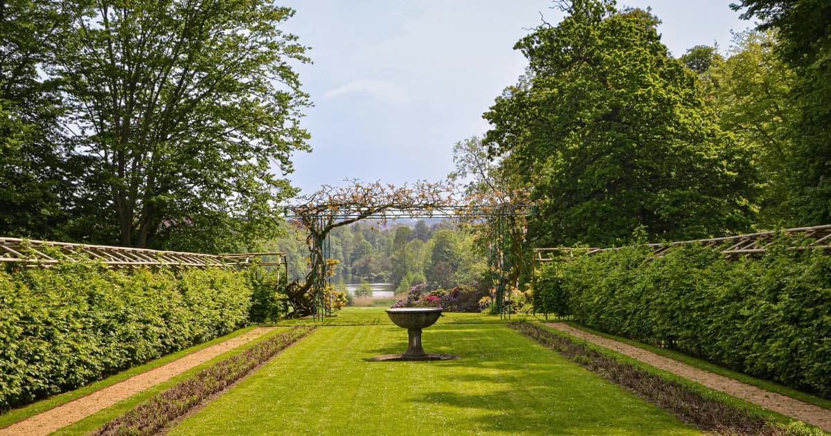Välskött trädgård med gräsmatta och planteringar